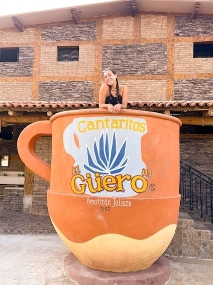 A large ceramic mug with 'Cantaritos' and 'Guero' branding, placed outdoors with a building in the background. 2