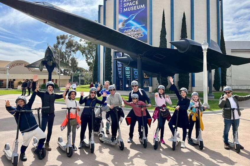 Un grupo de personas sobre tablas flotantes frente a un edificio con un letrero grande que dice 'SPACE MUSEUM'. 2