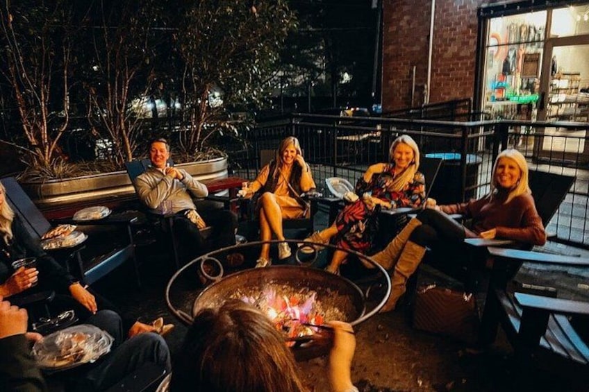 People sitting around a fire pit at night. 4