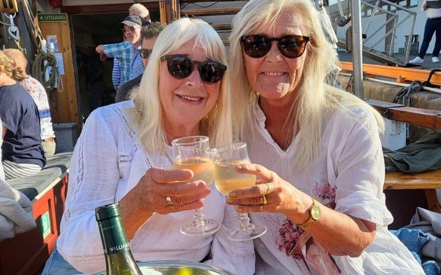 Two people toasting with drinks on a boat. 3