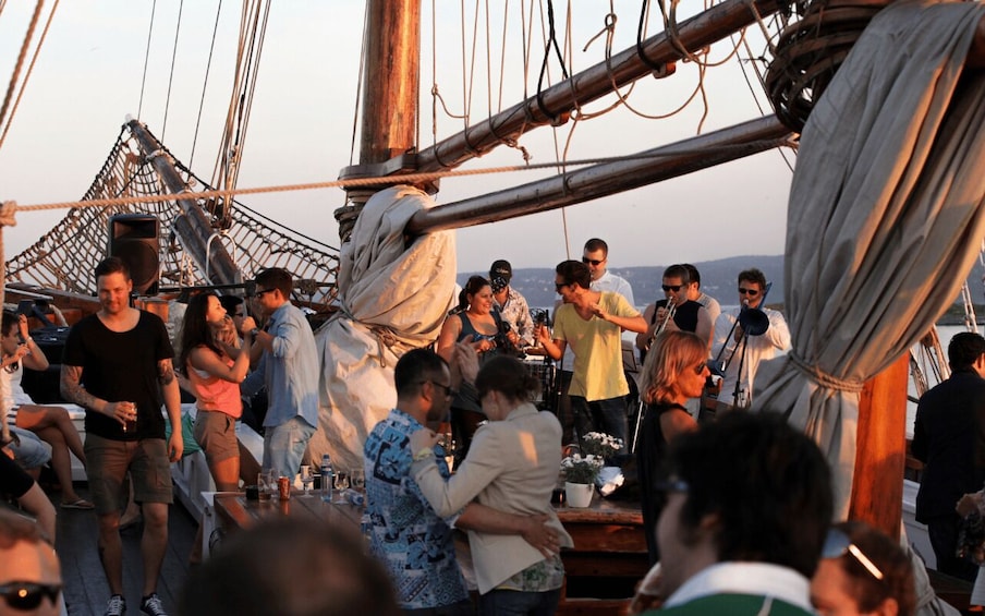 A group of people on a ship with a netted structure in the background. 1