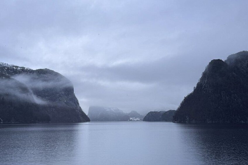 A calm lake surrounded by mountains with a cloudy sky. 4