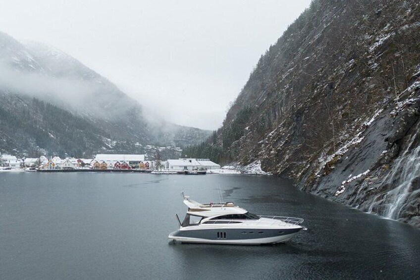 A boat on calm water, a snowy mountain in the background, and a small settlement with colorful buildings. 2