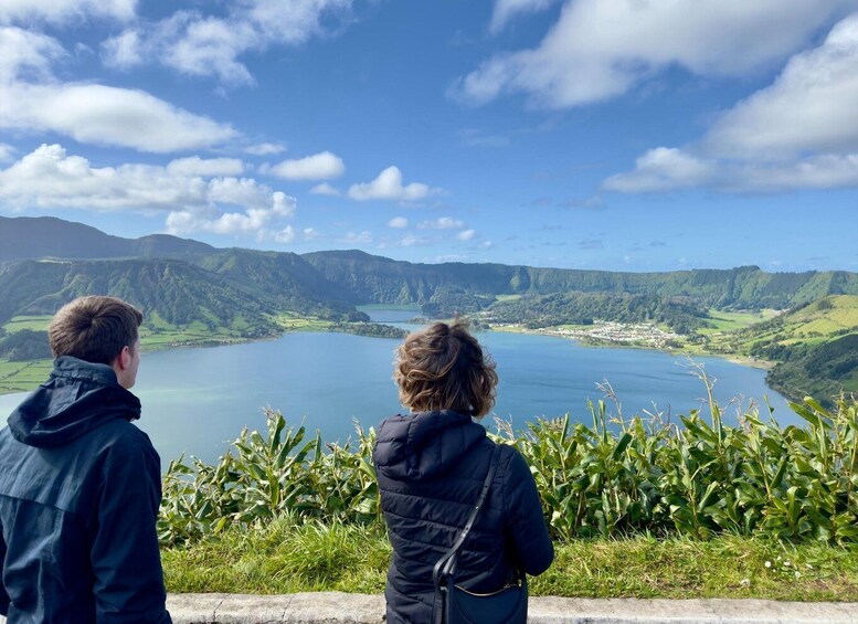 Two people overlooking a lake surrounded by hills. 3