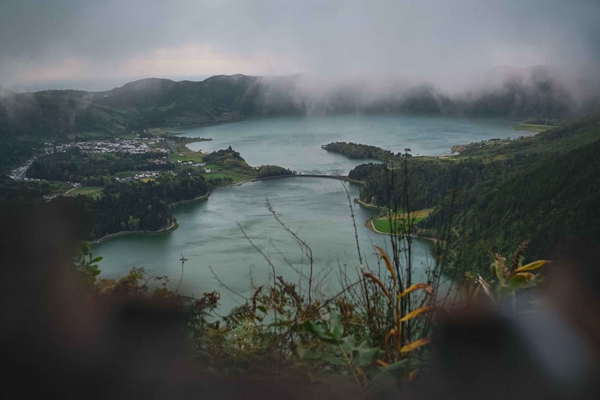A lake surrounded by hills, a bridge, and a small town. 5