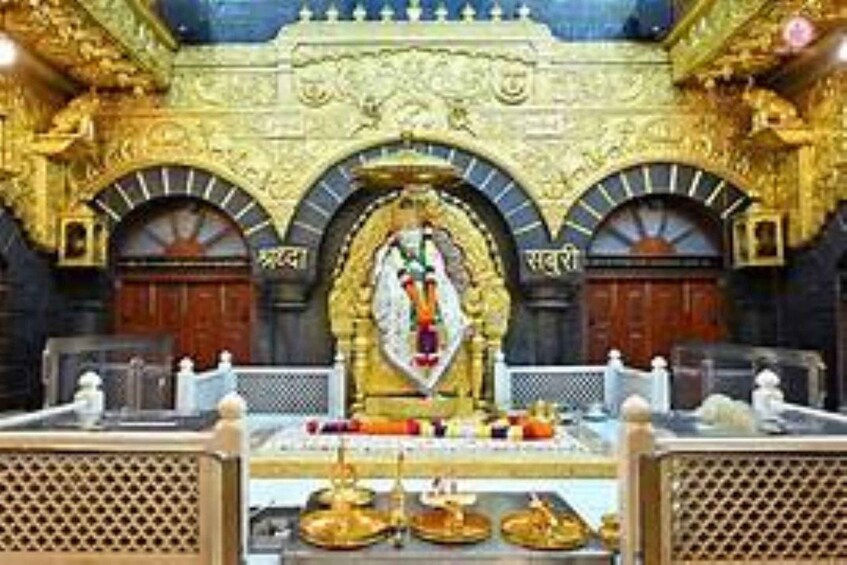 A temple interior with ornate golden arches and a central deity statue. 4