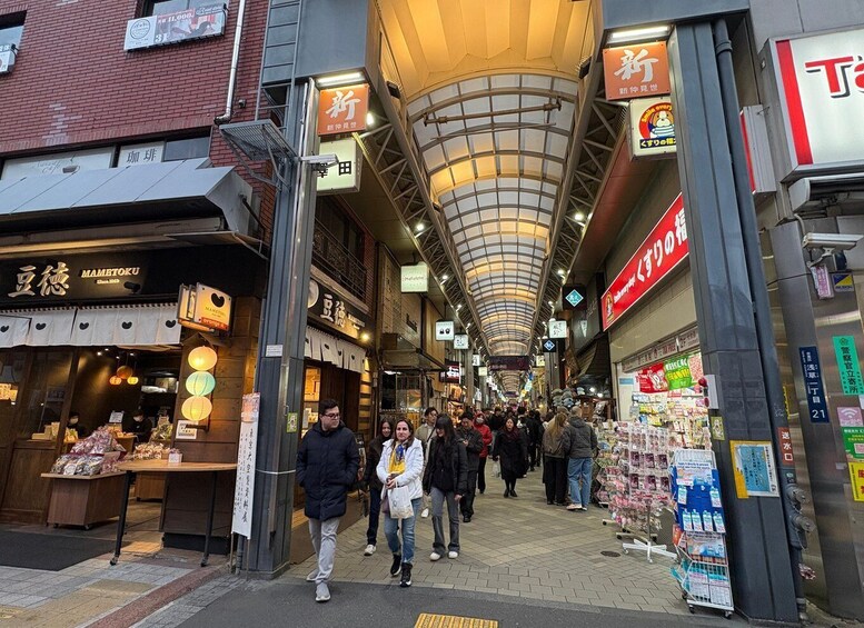 A busy indoor market with various shops and signs, including a visible ATM and a covered walkway. 3