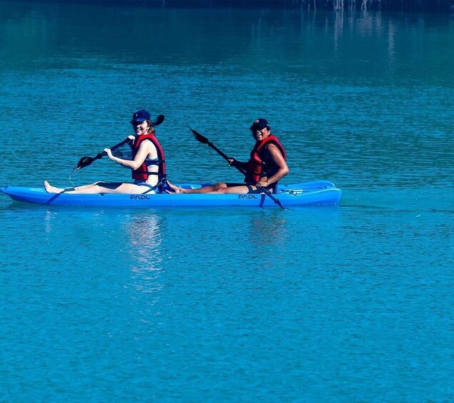 Two people kayaking on a calm lake. 4