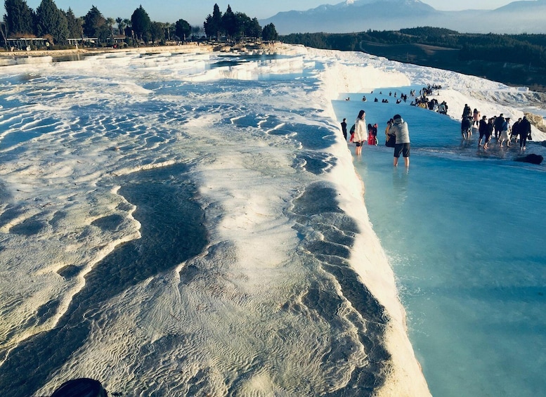 A geothermal area with mineral deposits and visitors. 2
