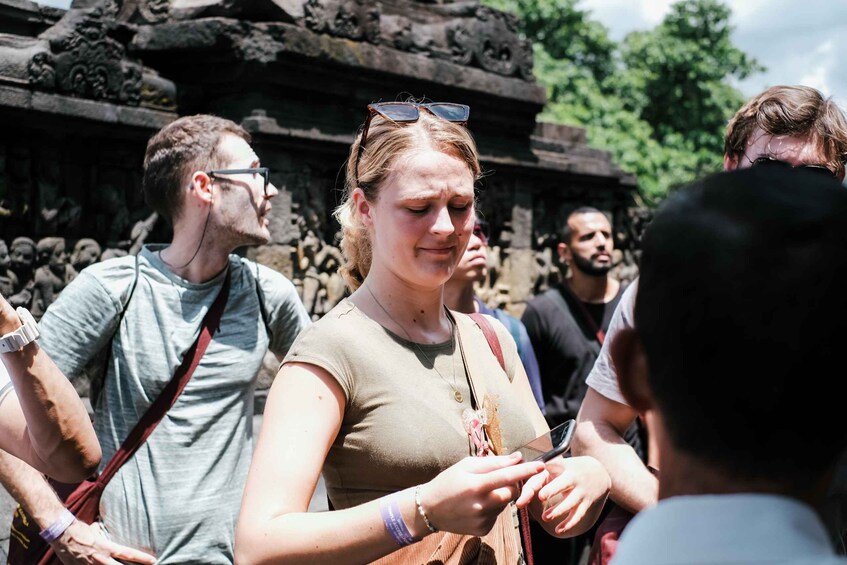 Tourists at a historical site with ancient stone carvings. 4
