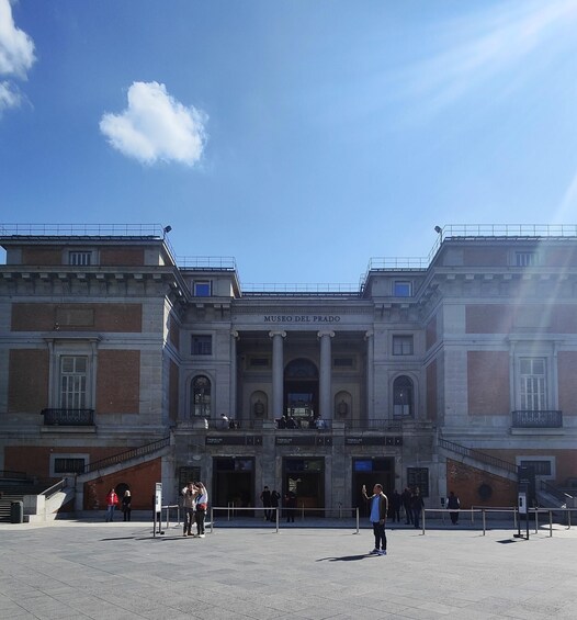 The Museo Del Prado's facade with people walking in front. 1