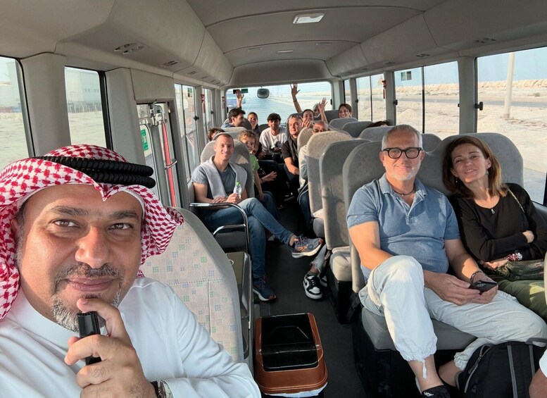 Un grupo de personas en un autobús, con un paisaje desértico visible a través de las ventanas. 1