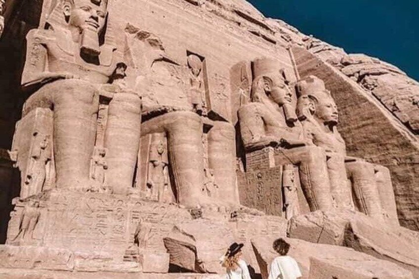 A large rock formation with carved statues of pharaohs. 3
