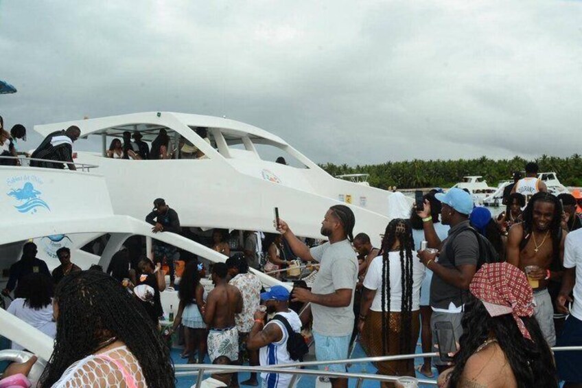 A group of people gathered around a white yacht with a blue logo, on a boat dock. 5