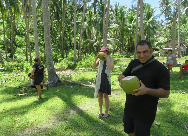 A group of people in a tropical setting with palm trees and greenery. 5