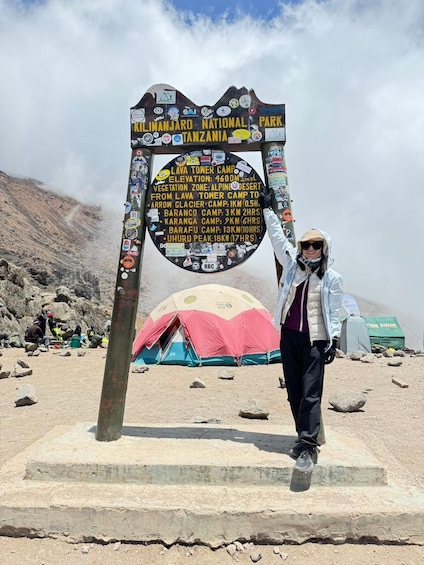 A signpost at Kilimanjaro National Park with information about various camps and their distances. 3