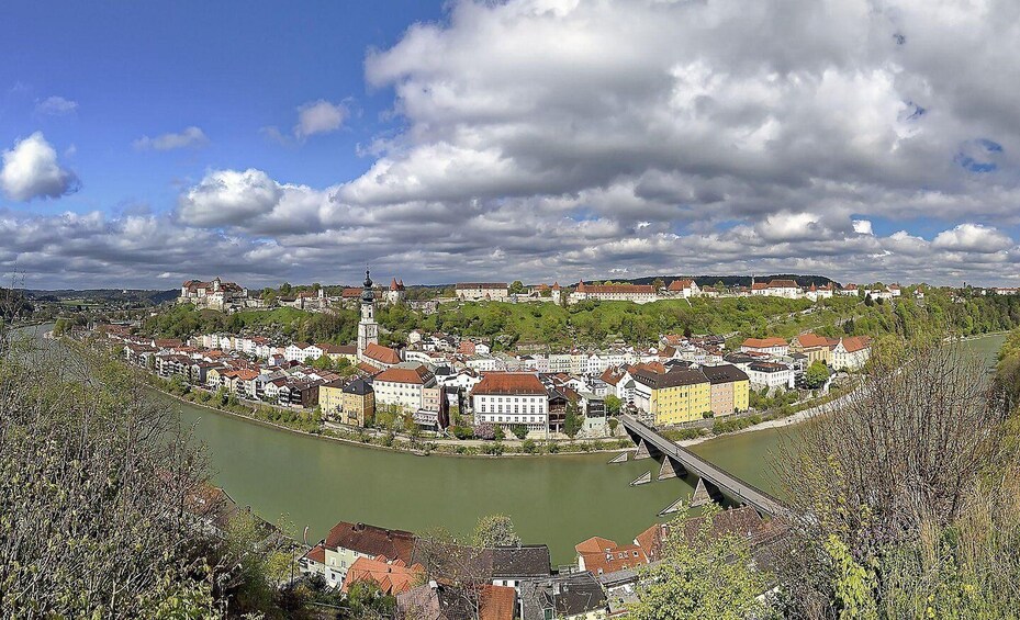 A river winding through a town with historic buildings and a castle on a hill. 2