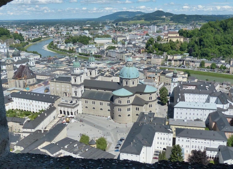 A cityscape with a prominent cathedral, a river, and surrounding greenery. 1