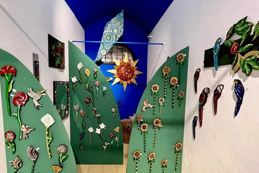 Una galería con paneles verdes decorados con flores y pájaros. 2