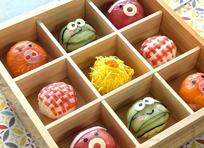 A wooden box with compartments containing various food items, some with faces drawn on them. 1
