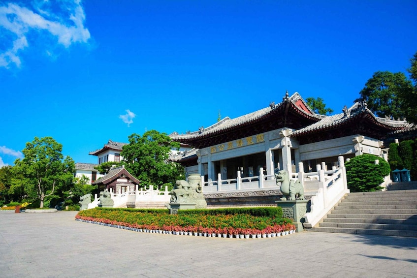 A traditional Chinese building with ornate architecture, surrounded by a well-maintained garden and a clear blue sky. 3