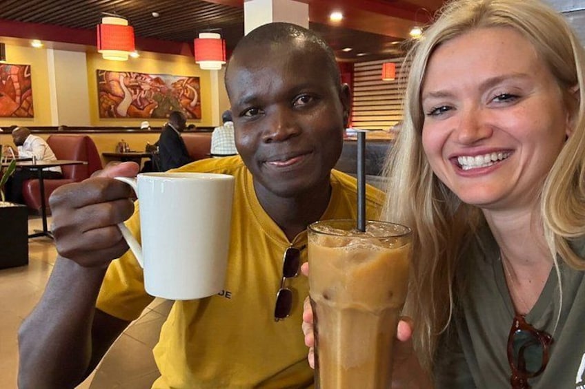 Una persona tiene una tazza bianca e un bicchiere di caffè ghiacciato in un ristorante. 3