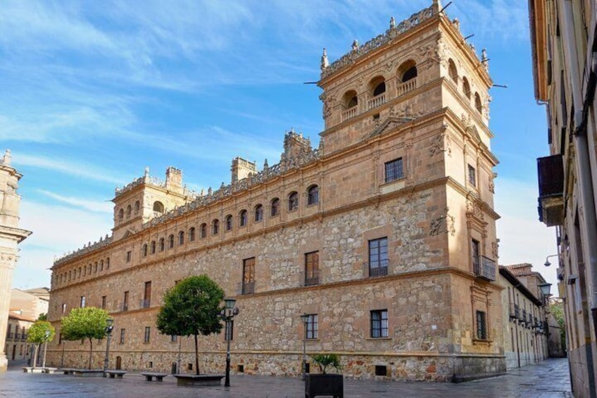 A historic stone building with multiple arches and a tower. 3