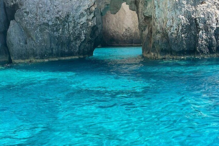 Mar azul claro con la entrada a una cueva rocosa. 2