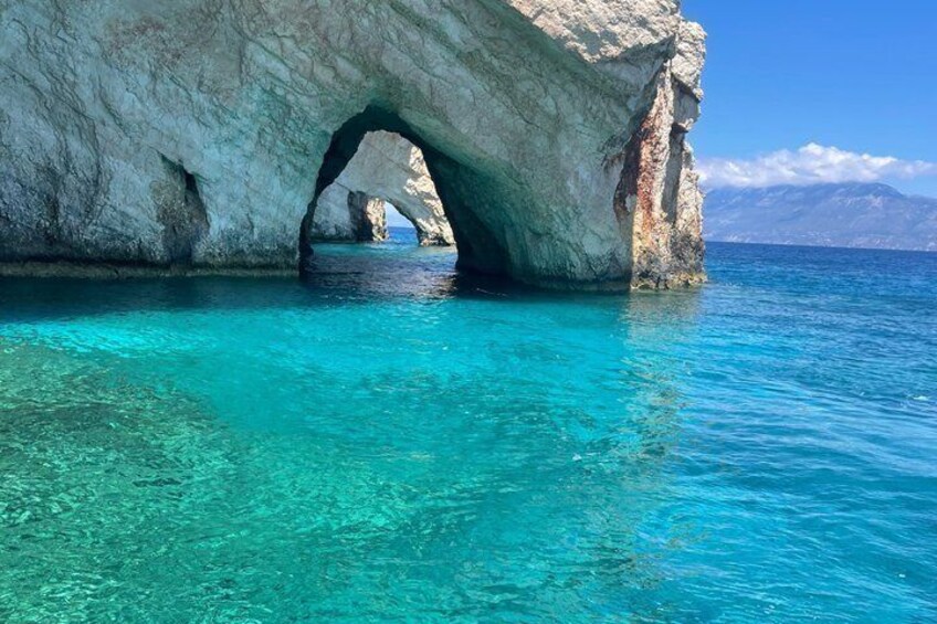 Una gran formación rocosa con un arco natural sobre aguas turquesas cristalinas. 3