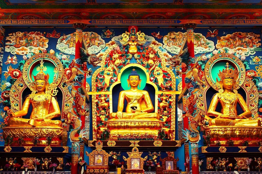 A brightly decorated temple with golden statues of Buddhas and intricate wall paintings. 4