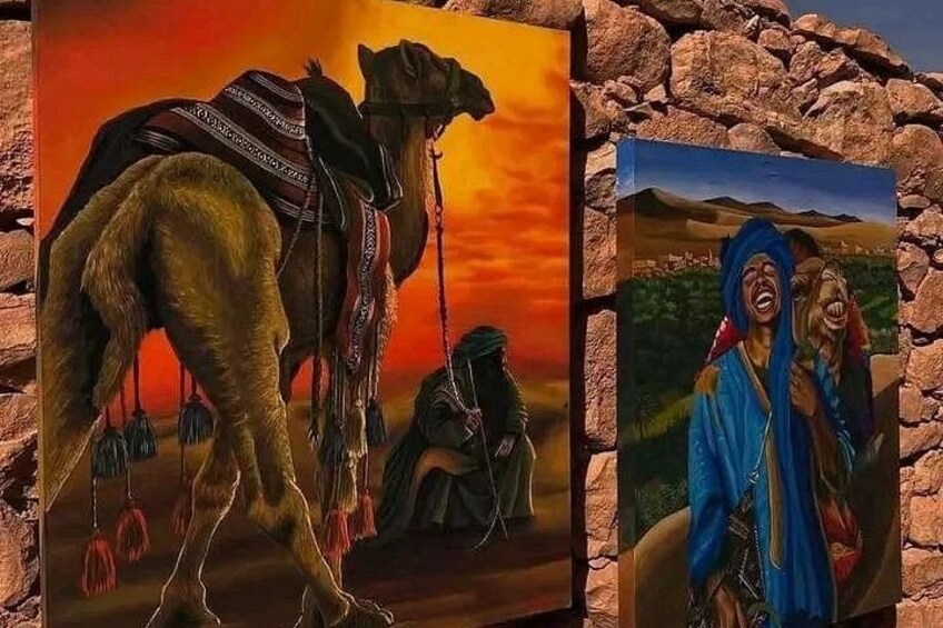 A camel with a saddle and a person in traditional attire. 1