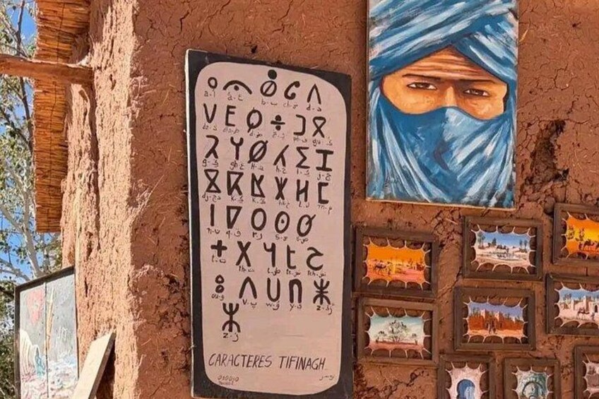 A wall with a sign displaying characters and a mural of a person. 3