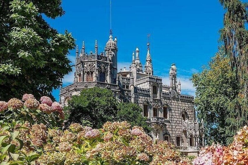 A Gothic-style castle surrounded by lush gardens and trees. 2
