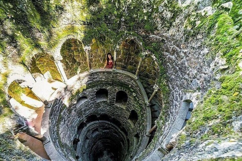 A stone spiral staircase in a lush, green environment. 1