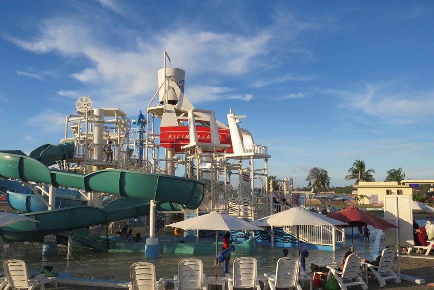 A water park with slides and pools, surrounded by umbrellas and chairs. 5