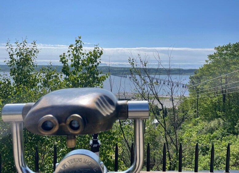 Binoculars, a fence, trees, and a bridge over water. 5