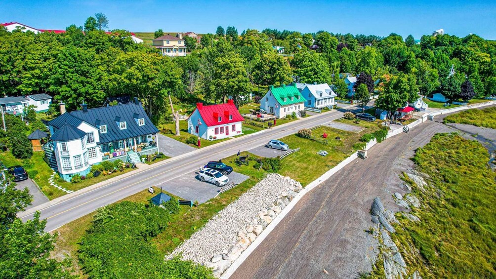 A residential area with houses, a road, and a hill with trees. 1
