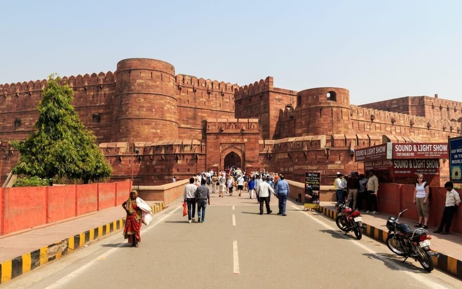 A large, historic fort with a crowd of people walking towards the entrance. 5