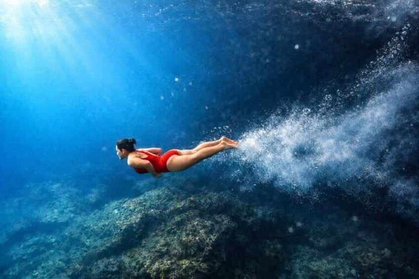 A person swimming underwater. 3
