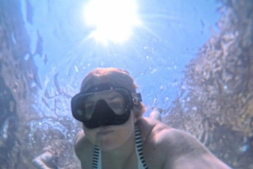 A person underwater, wearing a snorkel mask and a life vest. 4
