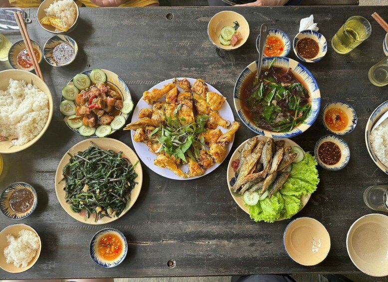 A variety of dishes including rice, grilled chicken, fish, and vegetables, served on a wooden table. 4