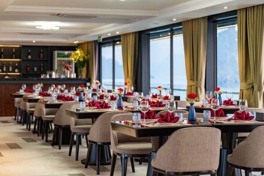 Un ristorante con tavoli apparecchiati per mangiare, sedie e un'area bar sullo sfondo. 4