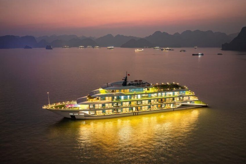 Una grande nave da crociera a più ponti illuminati di notte, con mare calmo. 1