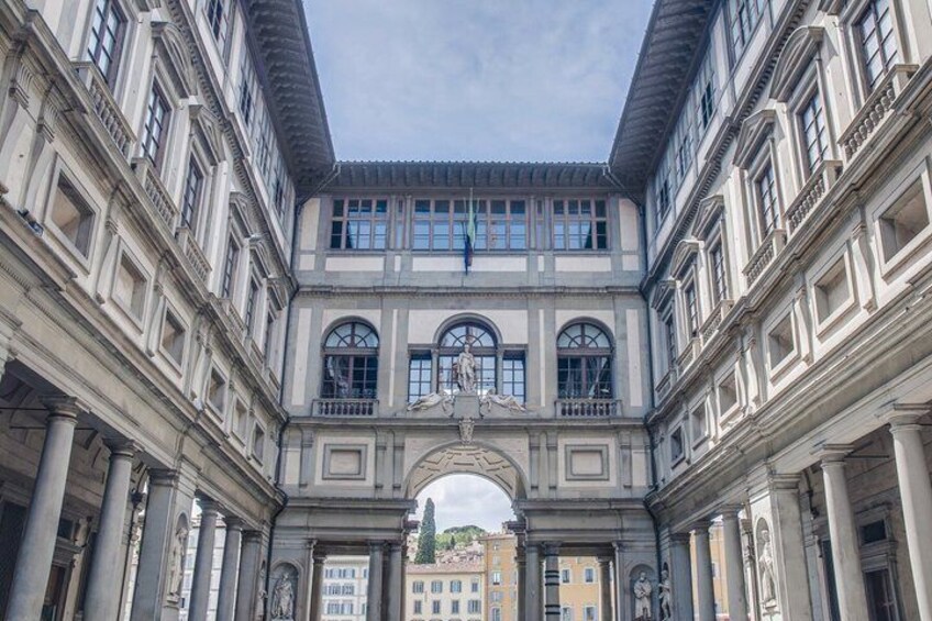 En klassisk bygning med en midterlig buesøjle, søjler og en symmetrisk facade. 3