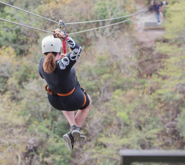 A person zip-lining through a forested area. 1