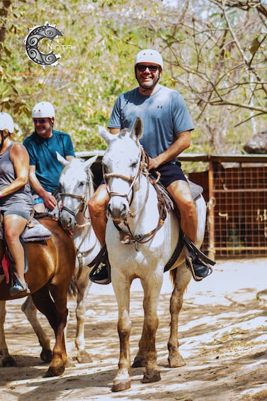 A person riding a horse, another person riding a horse, and a third person walking a horse. 5