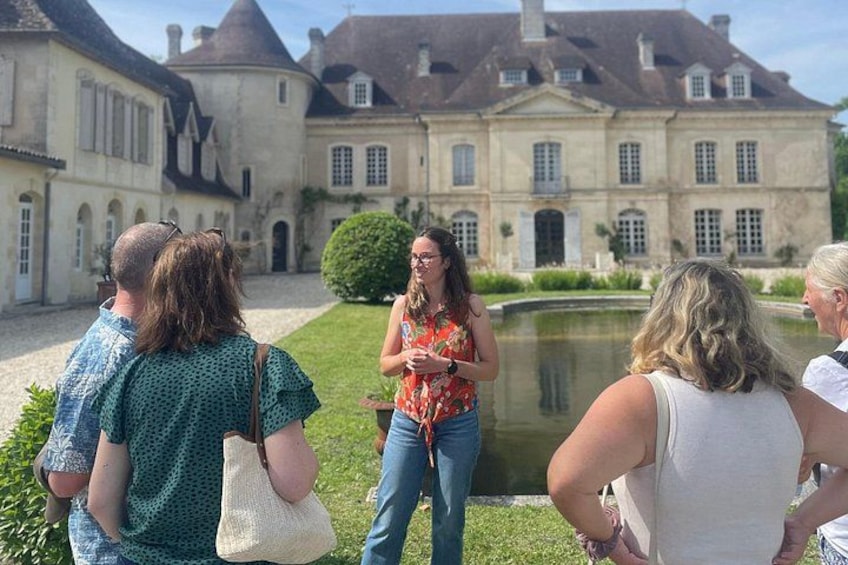 A group of people standing in a courtyard with a large historic building in the background. 1
