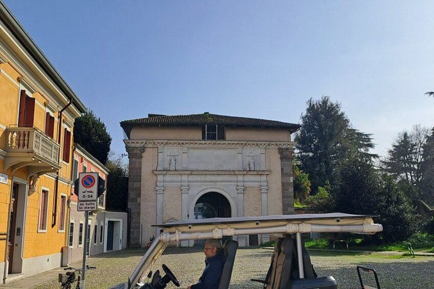 Un edificio storico con un grande ingresso ad arco, un cartello che vieta la sosta e un uomo che manovra una gru. 4