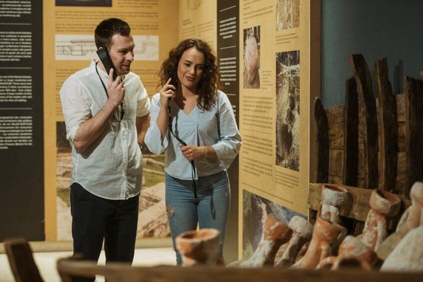 Dos personas observan una exposición con paneles informativos y artefactos. 5