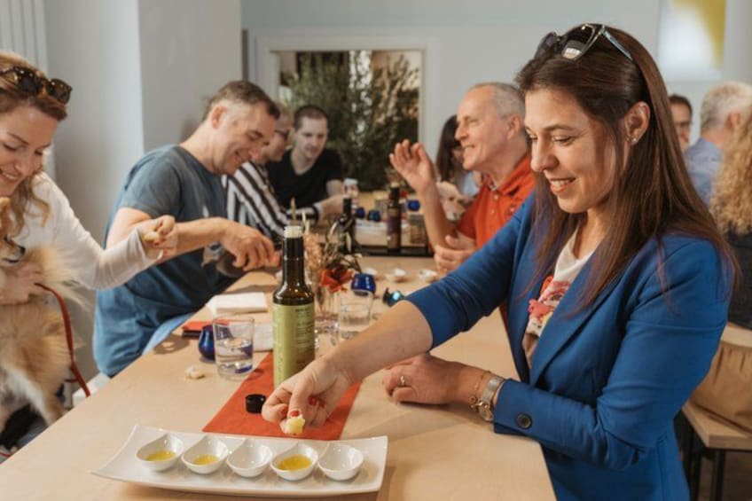Un grupo de personas sentadas a una mesa con una botella, vasos y un plato de comida. 1